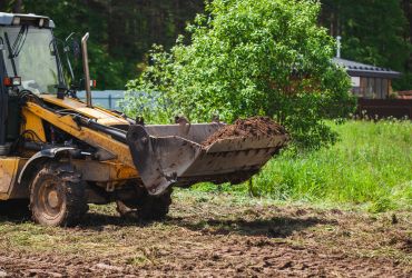 skid steer moving dirt on cleared land